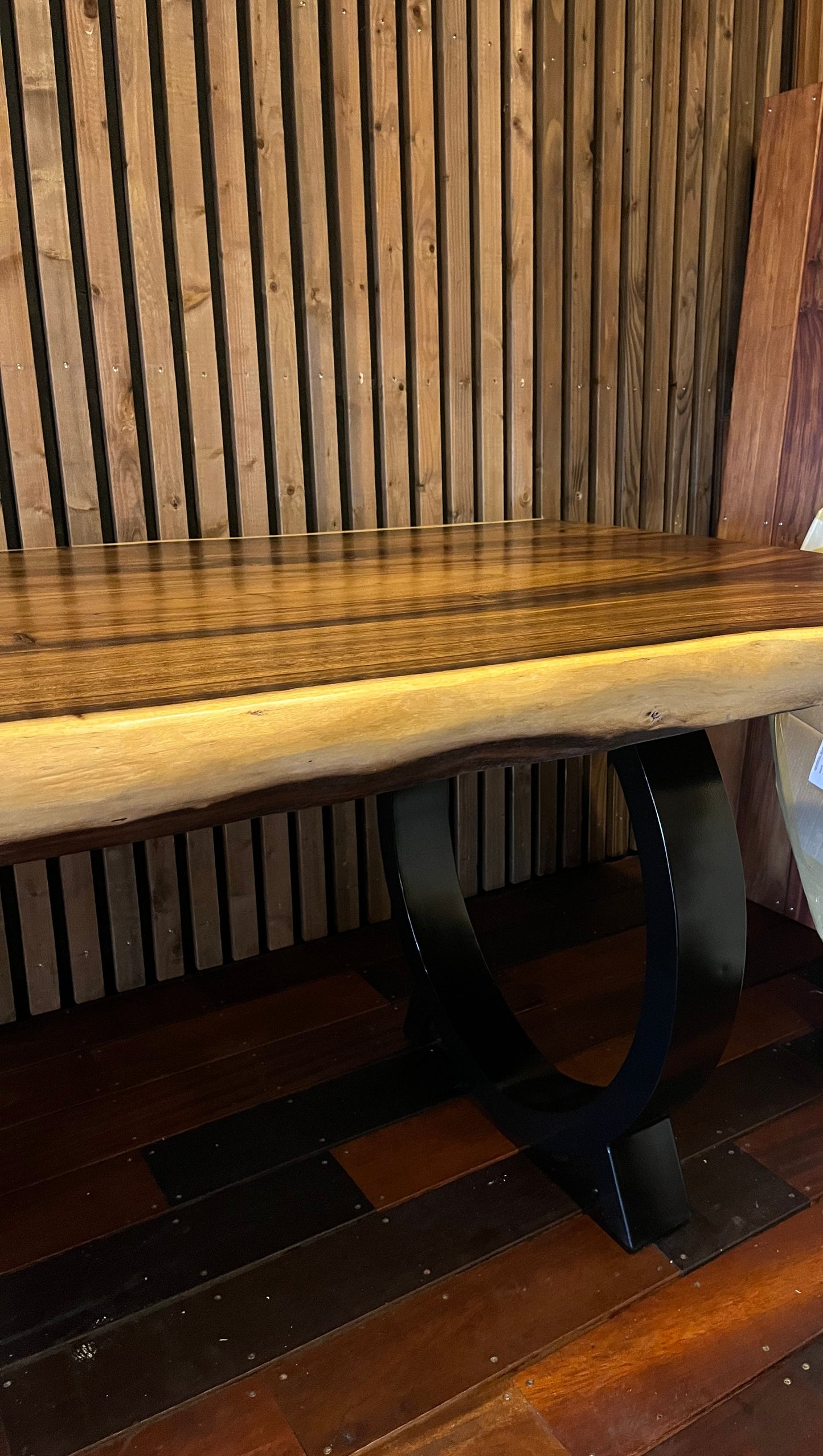Table en bois massif brut avec tranche naturelle, mobilier artisanal en bois exposé sur salon professionnel