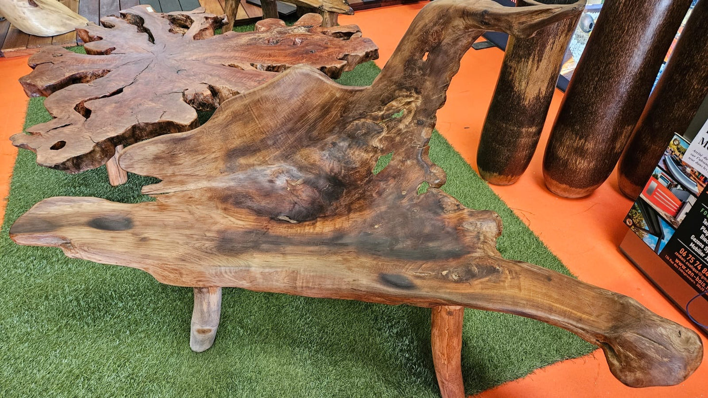 Banc en bois racine massif sculpté, mobilier artisanal en bois naturel aux formes organiques exposé en salon