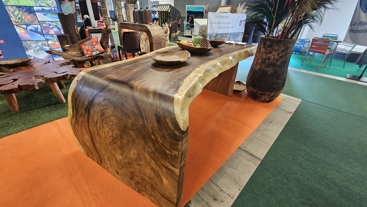 Table en bois massif brut avec tranche naturelle, mobilier artisanal en bois exposé sur salon professionnel